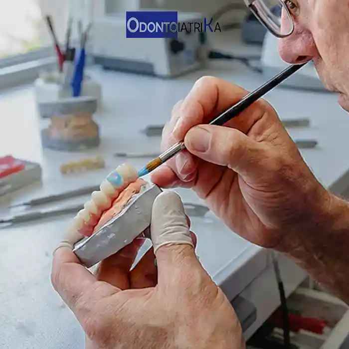 Tecnico odontotecnico al lavoro sulla costruzione di denti definitivi in ceramica